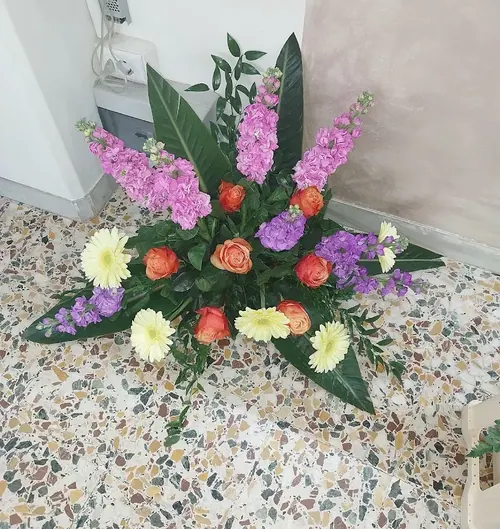Composizione con violaciocche lilla, rose arancio e gerbere gialle