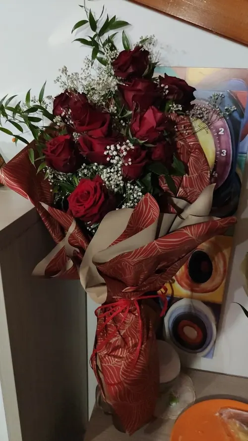 Mazzo di rose rosse con gypsophila e ruscus in carta decorata bordeaux
