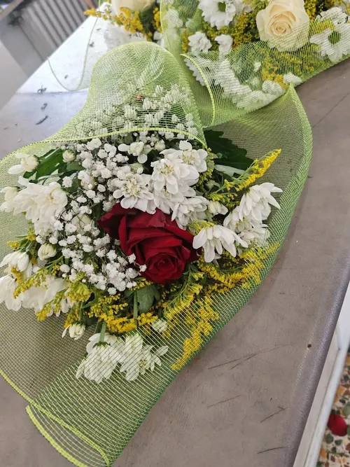 Bouquet bianco con una rosa rossa, margherite e solidago