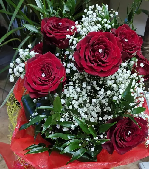 Bouquet di rose rosse con gypsophila e carta rossa