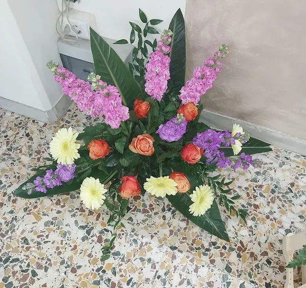 Composizione con violaciocche, rose arancio e gerbere gialle